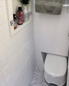 Banheiro compacto da Sprinter 416 Extra Longa, com box e pia embutida, em design moderno.