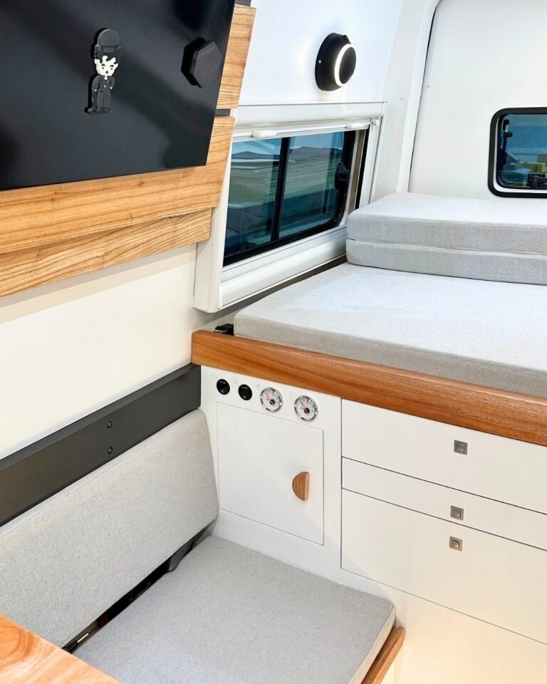 Sala de estar da Sprinter Trio com sofá, iluminação LED e cama extra retrátil, em design moderno e funcional, ideal para viagens em grupo