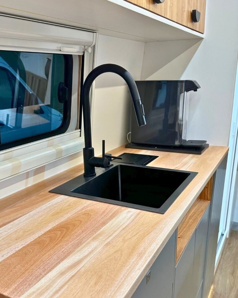 Cozinha da Sprinter Trio com fogão e pia ampla, em design moderno e funcional, ideal para viagens em grupo