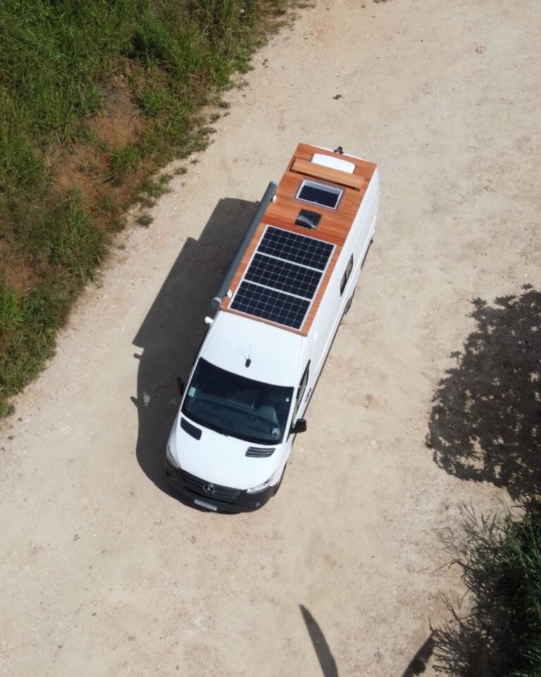 Área externa da Sprinter Trio com deck no teto e painéis solares, em design moderno e funcional, ideal para viagens em grupo.