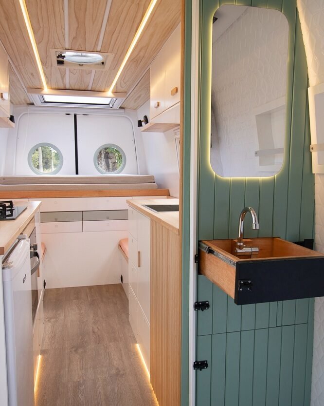 Banheiro compacto da Sprinter 416 Extra Longa, com bo, pia embutida, vaso portátil e armários, em tons claros e design moderno